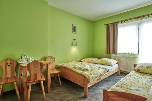 a bedroom with two beds and a table and chairs at Nędzówka in Ząb