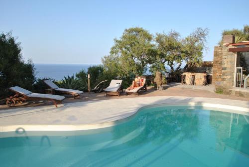 een zwembad met stoelen en een huis bij Resort La Casa Dei Fiori in Pantelleria