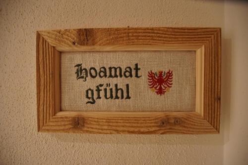 a wooden picture frame on a wall with the words diamond quilt at Gasthaus Goglhof in Fügenberg