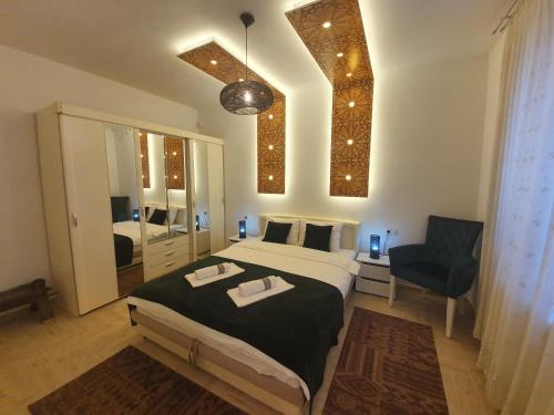 een slaapkamer met een bed, een stoel en een spiegel bij Golden Gate Apartment Sarajevo in Sarajevo
