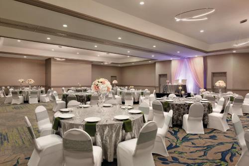 a ballroom with tables and white chairs and a room at Radisson Hotel Lenexa Overland Park in Lenexa