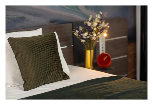 a bed with a pillow and a vase of flowers at Novotel Paris Porte Versailles in Paris