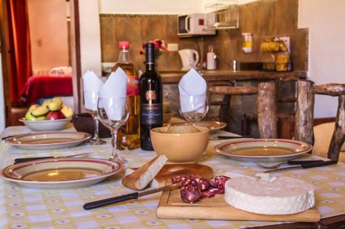a table with plates of food and bottles of wine at Cabañas Tilcara Mia in Tilcara