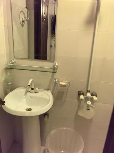 a bathroom with a sink and a mirror and a toilet at "Service Apartments Karachi" Ocean View 2 Bed Room Apt in Karachi
