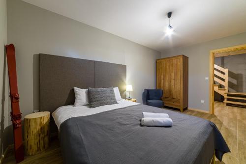 a bedroom with a large bed and a blue chair at Dziadkowka in Gliczarów