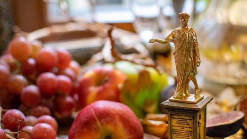 a statue of a crucifix on a table with apples at Shato Luxe in Odesa