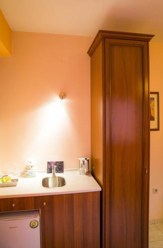 a kitchen with a sink and a wooden cabinet at Yiannis Apartments in Ioannina