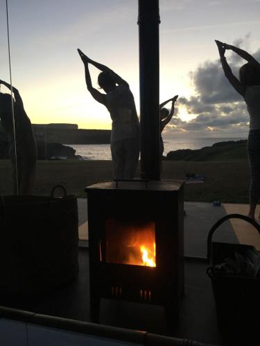 a fireplace with two people standing next to a fire at La Lagartija Adults Only in Ajo