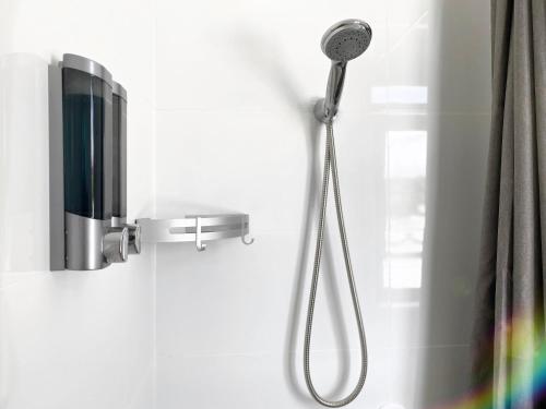 a shower with a shower head in a bathroom at Commercial Motel in Hay