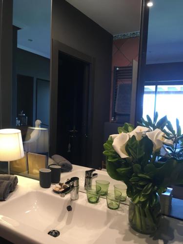 a bathroom sink with a vase of flowers on it at La Lagartija Adults Only in Ajo