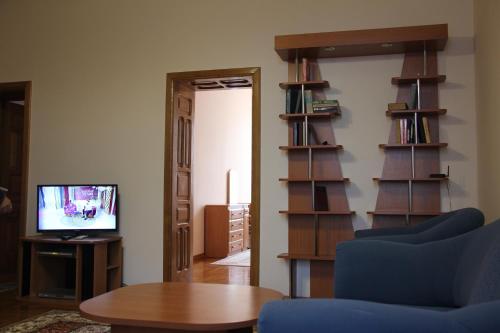 a living room with a blue couch and a tv at Apartments Domovik ,Kirilla i Mefodiya, 5 in Mukacheve