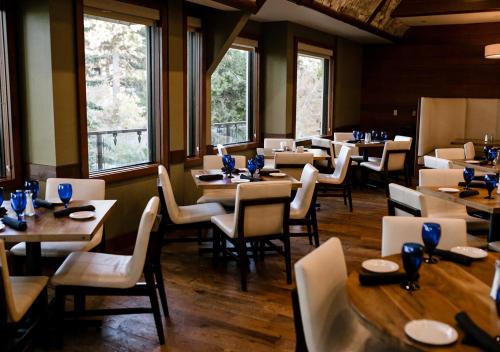 a dining room with tables and chairs and windows at Lake Arrowhead Resort & Spa in Lake Arrowhead