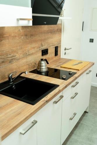 a kitchen with a sink and wooden counter top at City Apartments Hannover in Hannover