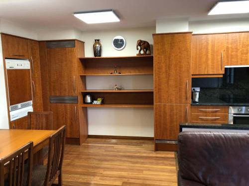 a kitchen with wooden cabinets and a wooden table and a table and chairs at Apartaments Vicus 2 con vistas a la Plaza Mayor de Vic in Vic