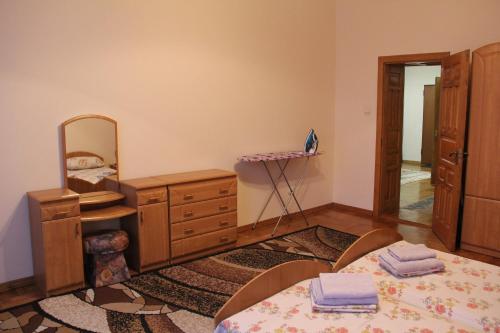 a bedroom with a bed and a dresser and a mirror at Apartments Domovik ,Kirilla i Mefodiya, 5 in Mukacheve
