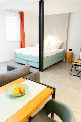 a room with a bed and a table with a bowl of fruit at City Apartments Hannover in Hannover