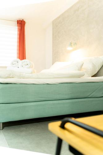 a bedroom with a bed with white sheets on it at City Apartments Hannover in Hannover
