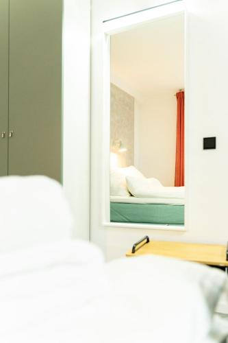 a bedroom with a mirror and a bed at City Apartments Hannover in Hannover