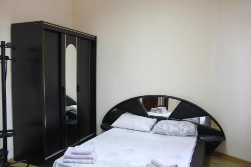 a bedroom with a black bed and a mirror at Apartments Domovik ,Kirilla i Mefodiya, 5 in Mukacheve