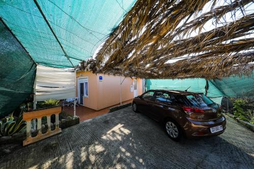 um carro estacionado em frente a uma casa com uma tenda em Apartments Tara - 70 m from beach em Brbinj