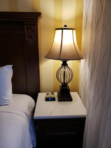 a lamp sitting on a night stand next to a bed at Arbutus Inn in Victoria