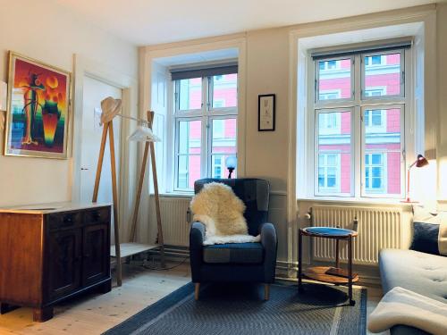 a living room with a dog sitting in a chair at ApartmentInCopenhagen Apartment 200 in Copenhagen