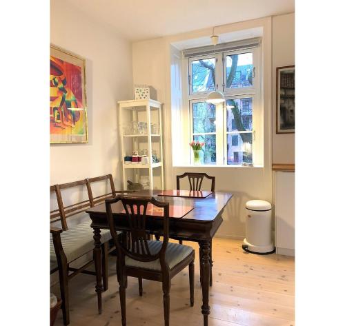 a dining room with a table and chairs and a window at ApartmentInCopenhagen Apartment 200 in Copenhagen