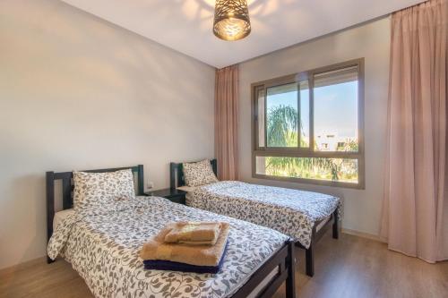 1 Schlafzimmer mit 2 Betten und einem Fenster in der Unterkunft Coup de cœur à Marrakech - idéal famille et couple in Marrakesch
