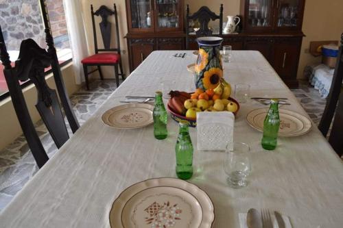 a table with plates and bottles and a bowl of fruit at Hotel Sierra Patlachique in San Juan Teotihuacán