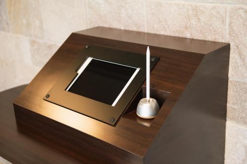 a table with a tablet and a candle on it at GRAND BASE Nagasaki Ekimae in Nagasaki