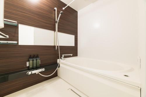 a bathroom with a shower and a sink at GRAND BASE Nagasaki Ekimae in Nagasaki