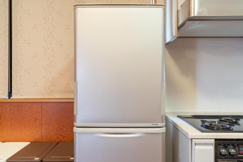 a white refrigerator in a kitchen next to a stove at HOLIDAY INN GARAKUTA in Ishigaki Island
