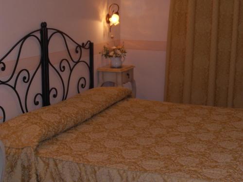 a bedroom with a bed and a table with flowers at Hotel Garnì Bartabel in Gargnano