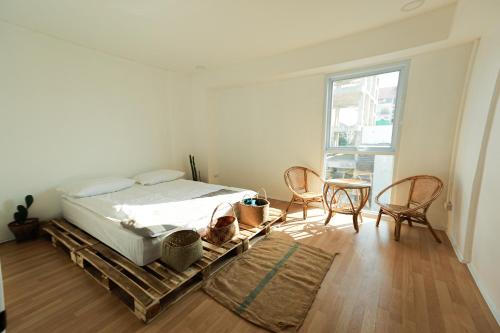 Un dormitorio con una cama y una mesa y sillas. en Petit Espace Boutique Hostel, en Vientiane