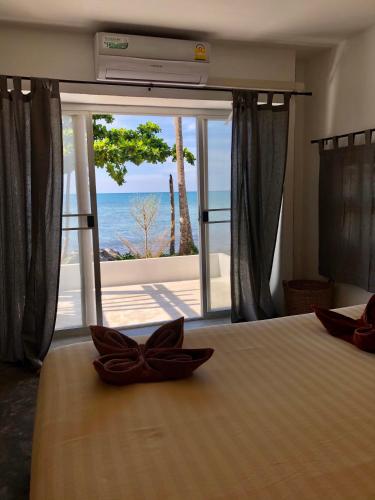 a bedroom with a bed with a view of the ocean at Paradise Cottage in Ko Chang
