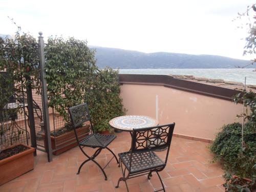 a patio with two chairs and a table on a balcony at Hotel Garnì Bartabel in Gargnano