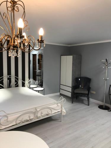 a bedroom with a bed and a chandelier at Charming studio in Pechersk in Kyiv