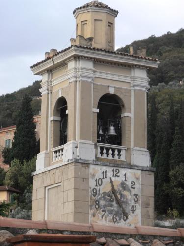 a large tower with a clock on top of it at Hotel Garnì Bartabel in Gargnano