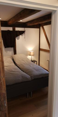a bedroom with a bed in a room with beams at Løðupakkhúsið - LPH - Mid Floor in Sørvágur