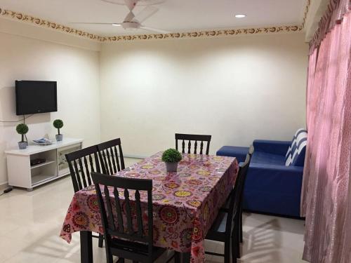a dining room with a table and a blue couch at langkawi homestay murah kawasan bandar in Kuah