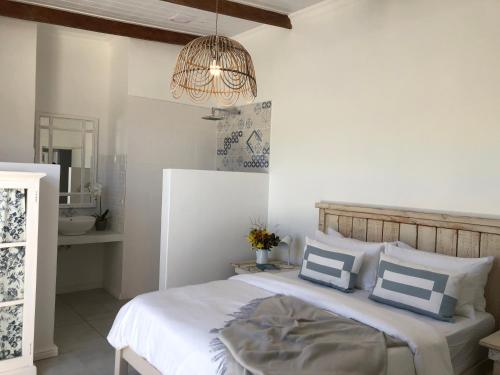 1 dormitorio con 1 cama con almohadas azules y blancas en Chasing daylight, en Struisbaai