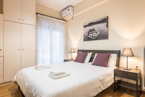 ein Schlafzimmer mit einem großen weißen Bett und einem Fenster in der Unterkunft Ioannis Cozy Apartment 500 meters from Acropolis museum in Athen