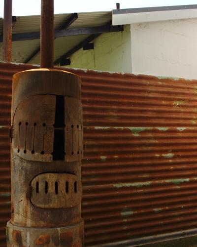 a wooden chair sitting next to a wooden fence at The Old Mushroom Farm in Howick