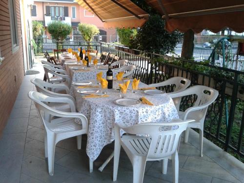 un lungo tavolo con sedie bianche su un patio di BED Magnolie a Lainate