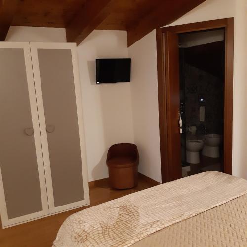 a bedroom with a bed and a bathroom with a toilet at La casetta nel claustro in Altamura
