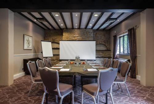 a conference room with a long table and chairs at The Priest House On The River in Castle Donington