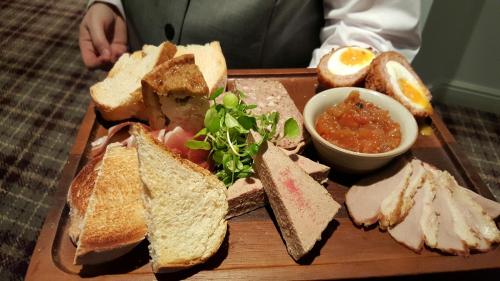 a plate of food with sandwiches and a bowl of soup at The Priest House On The River in Castle Donington