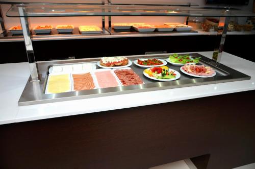 a display case with many different types of food at Breeze Boutique Athens by Prima Hotels in Athens