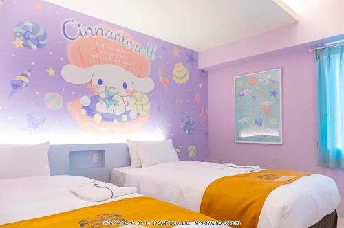 a bedroom with two beds and a hello kitty wall at HOTEL OKINAWA WITH SANRIO CHARACTERS in Naha