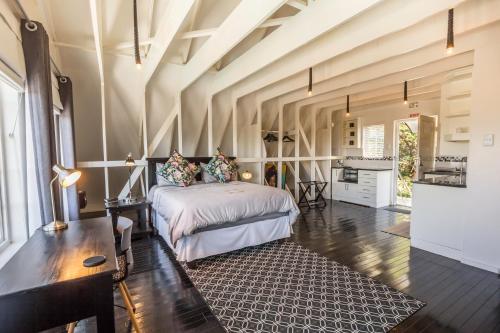 ein Schlafzimmer mit einem Bett und einem Tisch in einem Zimmer in der Unterkunft Oliver's Bed and Breakfast in Mtunzini
